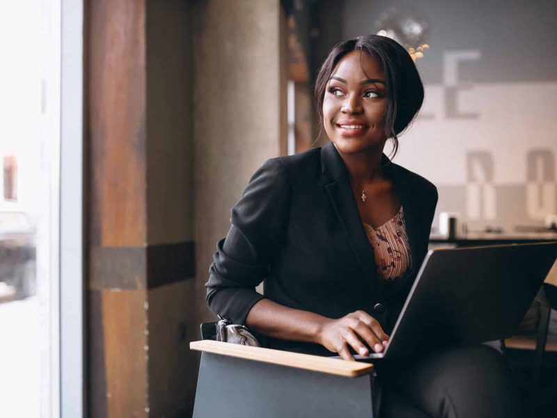 african-american-business-woman-working-on-a-computer-in-a-bar-scaled